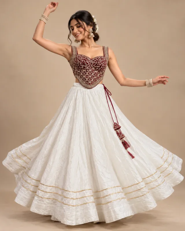 Ivory Lehenga with Maroon Embroidered Corset Choli — mid-turn with the skirt open