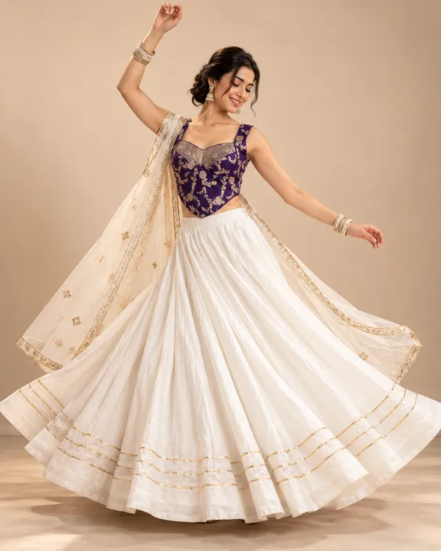 Ivory Lehenga with Purple Brocade Corset Choli — mid-turn with the skirt and dupatta flying