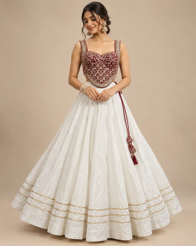 Ivory Lehenga with Maroon Embroidered Corset Choli — front view of the ivory skirt and maroon corset choli